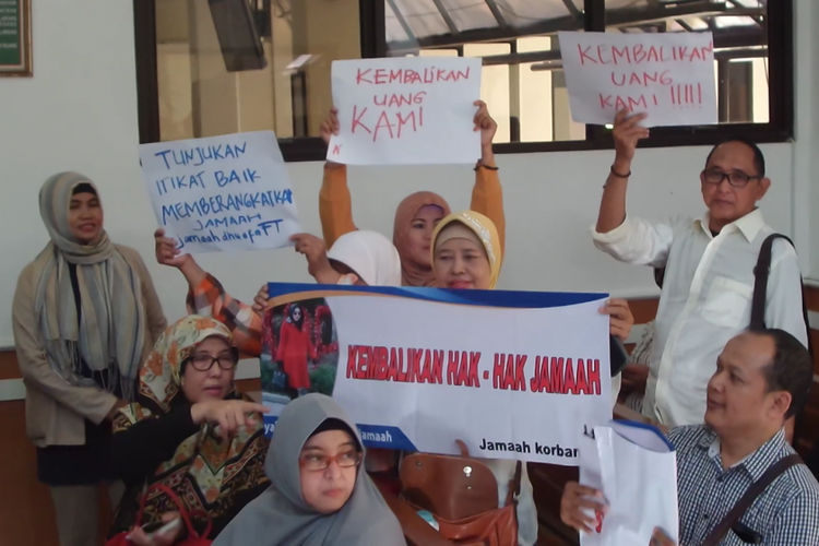 Sejumlah korban agen travel umrah PT First Travel mengacungkan spanduk saat menghadiri sidang perdana kasus dugaan penipuan dan penggelapan uang calon jamaah di Pengadilan Negeri Depok, Senin (19/2/2018).