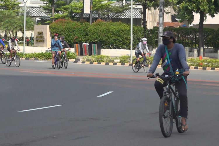 Sejumlah warga bersepeda di kawasan Bundaran HI, Jakarta Pusat, Minggu (31/5/2020).  Mereka menggunakan masker.