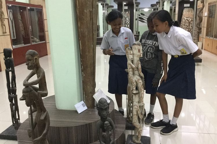Asria Rogi, Tifany Mambu dan Ecy Kayukatui, tiga orang siswi dari SMP Advent Padang Bulan, Kota Jayapura, saat melihat koleksi patung milik Suku Asmat yang berada di museum tertua milik Universitas Cenderawasih.