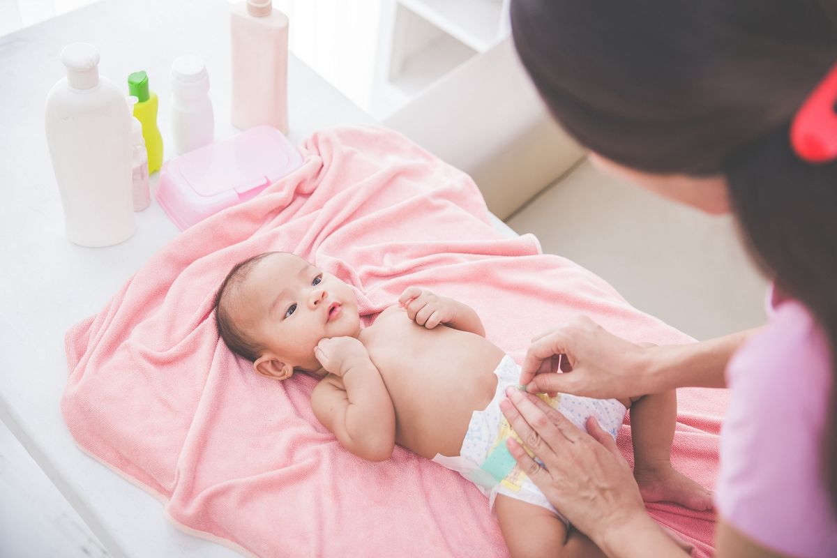 ilustrasi ibu sedang membersihkan BAB bayi