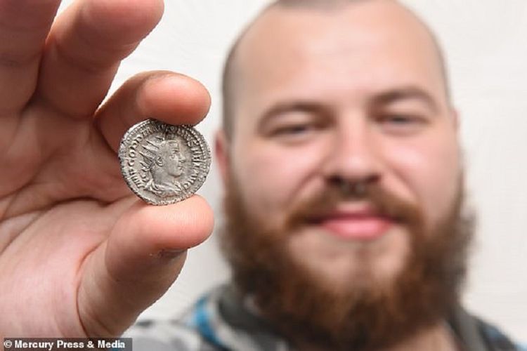 Chris Lyn menunjukkan koin dari era Romawi Kuno berusia 1.800 tahun yang ditemukannya.