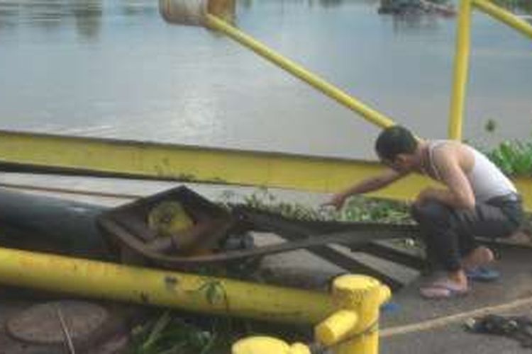 Salah seorang warga menunjukkan dermaga  di Desa Talang Pangeran  Pemulutan yang rusak Ditabrak ponton pasirribuan kubik