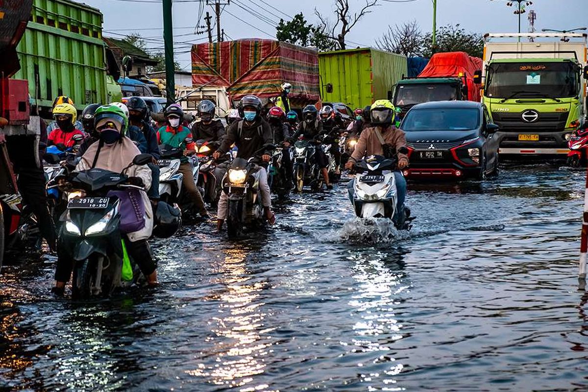 Kendaraan bermotor menembus jalan raya pantura Demak KM 8 ruas Demak-Semarang yang terendam limpasan air laut ke daratan (rob) di Demak, Jawa Tengah, Rabu (13/5/2020). Banjir rob yang melimpas ke jalur utama pantura Demak setinggi 15-40 sentimeter itu menyebabkan kemacetan lalu lintas sepanjang sekitar 7,5 kilometer dari Kabupaten Demak menuju Kota Semarang dan sekitar 1 kilometer dari Kota Semarang menuju Kabupaten Demak.