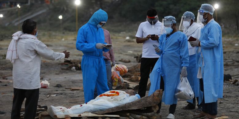 Anggota keluarga memberi penghormatan terakhir kepada kerabat mereka Rajendra Prasad Mishra, seorang pria berusia 62 tahun yang telah kehilangan nyawanya karena infeksi virus corona sebelum dikremasi di Sungai Gangga di Phaphamau di Prayagraj, India, Sabtu (8/5/2021).