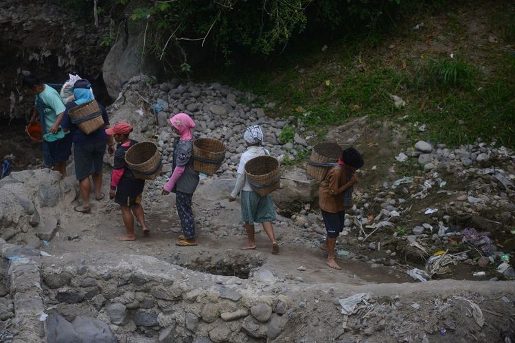 Potret buruh tambang sisa erupsi Gunung Merapi di Sungai Grawah, Desa Gubug, Cepogo, Boyolali, Jawa Tengah, Senin (13/7/2020). Mereka mendapat upah Rp 20.000 per hari jika material sisa erupsi Gunung Merapi yang mereka kumpulkan tersebut laku terjual.