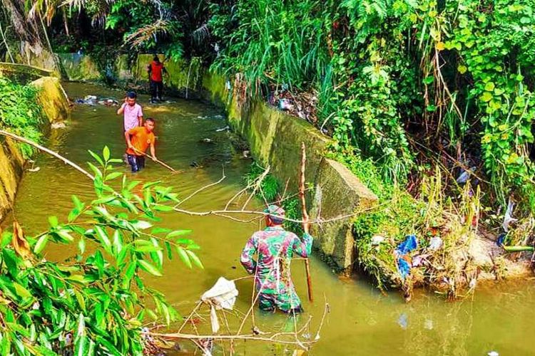 Petugas TNI dibantu warga mencari seorang balita yang jatuh dan diduga hanyut di parit di Jalan Datuk Tabano, Kecamatan Bangkinang Kota, Kabupaten Kampar, Riau, Minggu (21/3/2021).