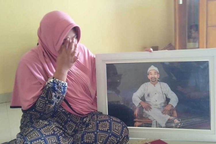 Ipah menunjukkan foto suaminya Zakaria, seorang calon kepala desa yang meninggal dunia sebelum pemilihan, Senin (24/10/2021)