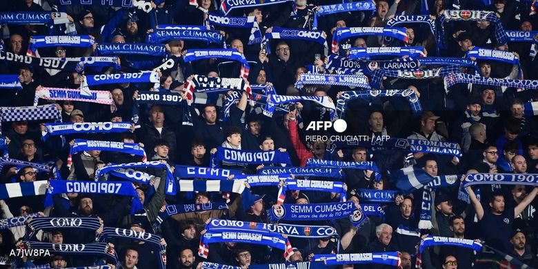 Pendukung Como melambaikan syal menjelang pertandingan sepak bola Serie A Liga Italia antara Como vs Inter Milan di Stadion Giuseppe Sinigaglia di Como pada 12 April 2026. (Foto oleh Piero CRUCIATTI / AFP)