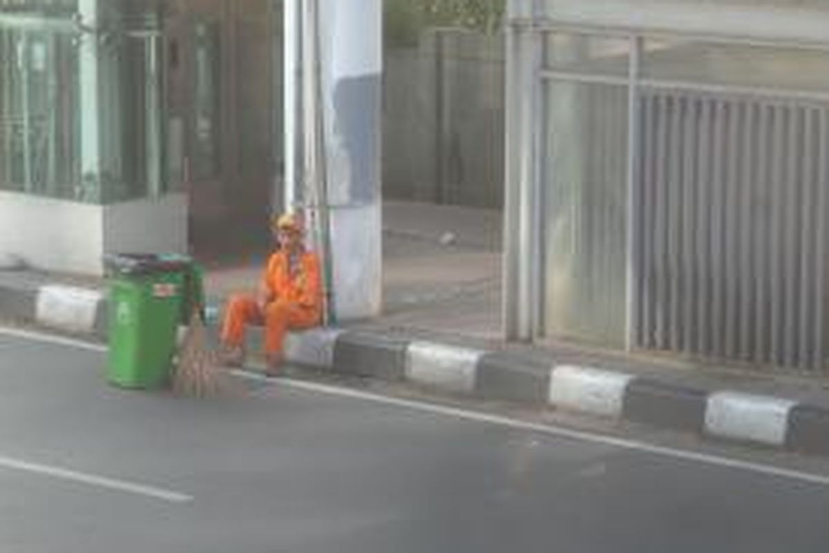 Salah seorang petugas Kebersihan tampak beristirahat sejenak usai menjalankan tugasnya di area car free day di kawasan Bundaran HI, Minggu (28/6/2015)