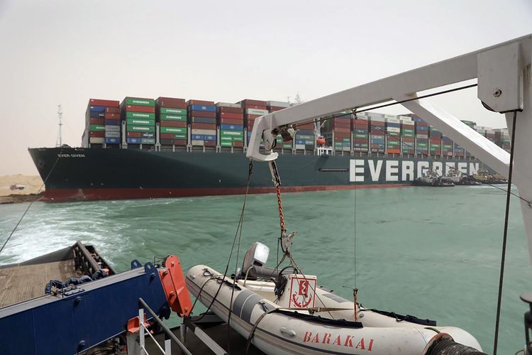 Foto yang dirilis Otoritas Terusan Suez pada Kamis (25/3/2021), memperlihatkan kapal Ever Given berbendera Panama masih tersangkut di kedua sisi Terusan Suez dan menutup jalur perairan krusial itu. Akibat Terusan Suez ditutup, 150 kapal harus antre masuk sembari menunggu evakuasi kapal Ever Given selesai.