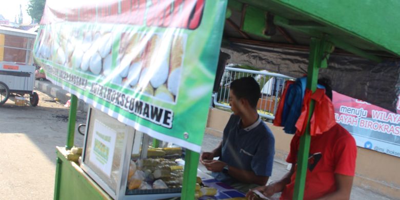 Pedagang lemang dengan merk Wak Saleh menunggu pembeli di Jalan Pelabuhan, Kota Lhokseumawe, Provinsi Aceh, Rabu (22/5/2019).