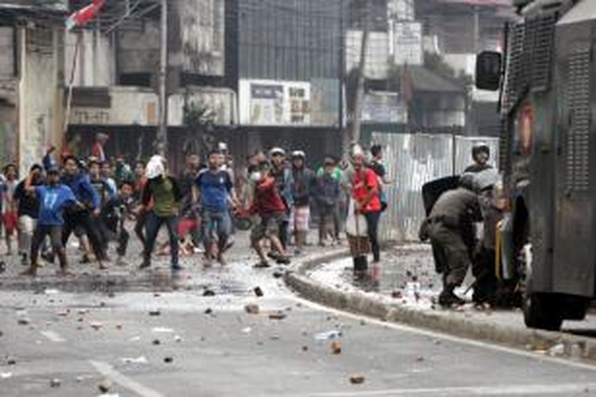 Warga Kampung Pulo, Jakarta Timur, terlibat kerusuhan dengan Satpol PP dan polisi di Jalan Jatinegara Barat, Kamis (20/8/2015). Bentrokan terjadi karena warga menolak digusur dan dipindahkan untuk normalisasi Kali Ciliwung.