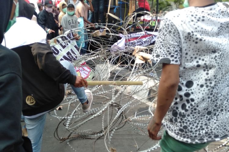 Massa aksi merusak kawat duri saat menggelar demonstrasidi depan gedung KPK, Senin (23/9/2019)