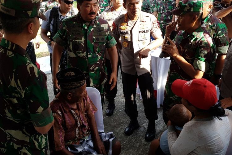 Panglima TNI dan Kapolri tengah melihat seorang warga yang sedang memeriksakan kesehatannya di acara Bakti Sosial TNI-Polri di PLBN Skouw, Kota Jayapura, Papua, Rabu (27/11/2019)(KOMPAS.COM/DHIAS  