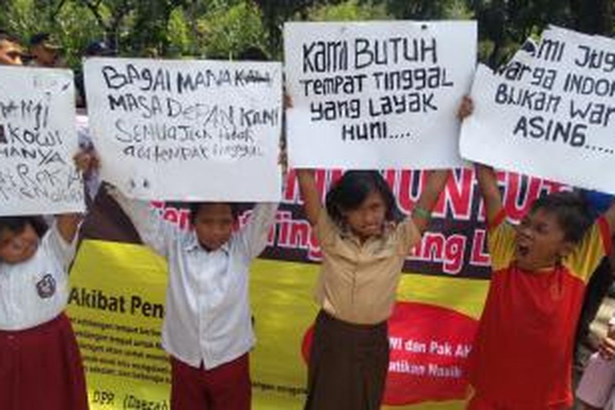 Sejumlah anak korban gusuran di Kebon Melati, Tanah Abang, Jakarta Pusat membentangkan poster di depan kantor gubernur DKI Jakarta, Senin (22/9/2014).

