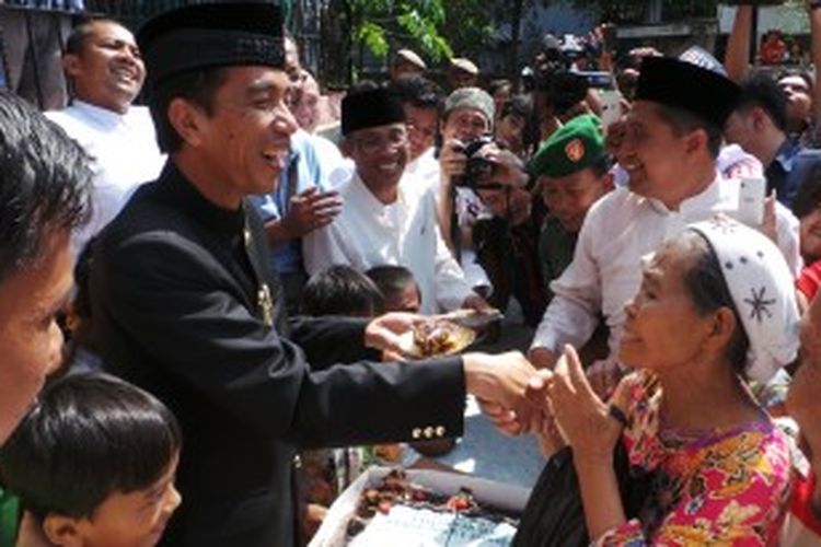 Gubernur DKI Jakarta Joko Widodo tampak sedang membagikan kue tart kepada warga Pademangan, Jakarta Utara. Pembahian kue tart itu dalam ranfka HUT DKI jakarta ke-486 tahun, Sabtu (22/6/2013).