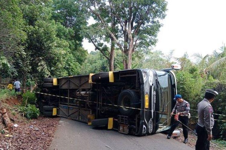 Sebuah bus pengangkut rombongan pramuka dari Kabupaten Ciamis, terguling di area Bumi Perkemahan Kiara Payung, di Dusun Cikeuyeup, Desa Sindangsari, Kecamatan Sukasari, Sumedang, Minggu (24/12/2023). (TRIBUNJABAR.ID/KIKI ANDRIANA)