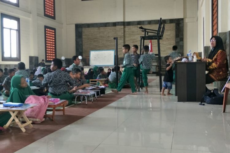 Tampak para siswa SDN 01 Cicau, Kecamatan Cikarang Pusat, Kabupaten Bekasi belajar di dalam GOR karena atap sekolah yang roboh pada Sabtu (2/2/2019).