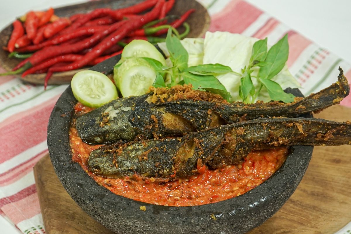 Tampilan pecel lele dengan ikan lele goreng keemasan, sambal merah pedas