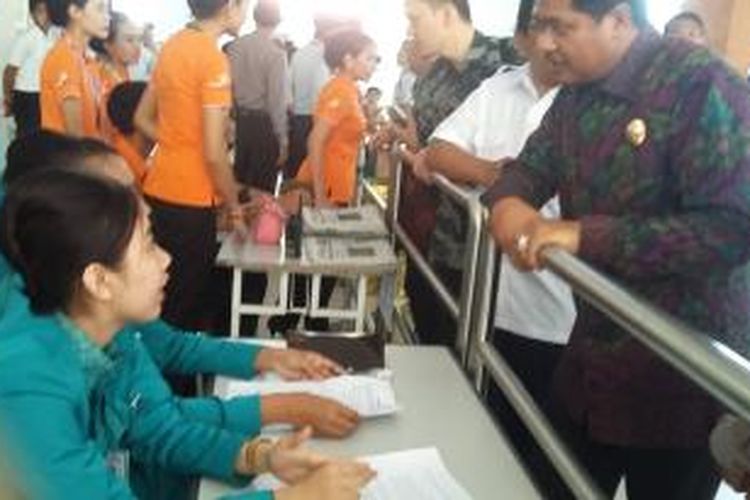 Wagub Bali Ketut Sudikerta saat meninjau petugas maskapai dalam melayani calon penumpang. 