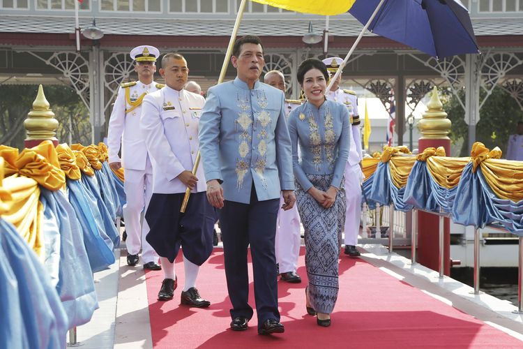 Raja Thailand Maha Vajiralongkorn (tengah) berjalan bersama selir kerajaan, Sineenat Wongvajirapakdi, di Dermaga Wasukri, Bangkok, pada 26 Januari 2021, dalam perayaan ulang tahun Sineenat ke-36. Sineenat disebut lahir pada 26 Januari 1985.