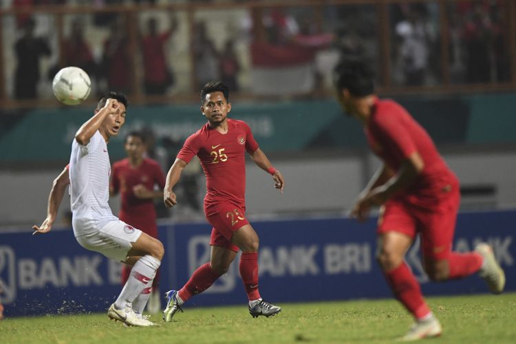 Pesepak bola Timnas Indonesia Andik Vermansah (tengah) mengumpan bola ke rekannya Irfan Jaya (kanan) saat melewati pesepak bola Timnas Hong Kong Yang Huang (kiri) dalam laga International Friendly Match di Stadion Wibawa Mukti, Cikarang, Bekasi, Jawa Barat, Selasa (16/10/2018). Pertandingan tersebut berakhir imbang dengan skor 1 - 1. ANTARA FOTO/Hafidz Mubarak A/wsj.