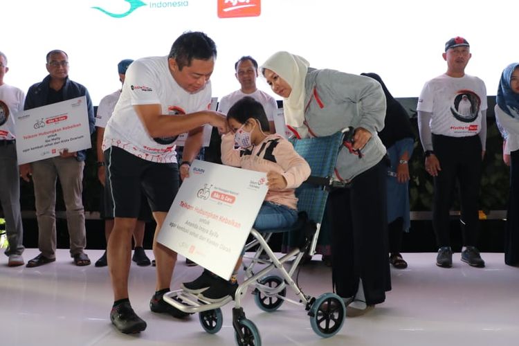 Direktur Utama Telkom Ririek Adriansyah (kiri) menyerahkan simbolis donasi kepada penderita kanker darah dalam acara Bike to Care IndiHome, di Jakarta, Rabu (4/9/2019).