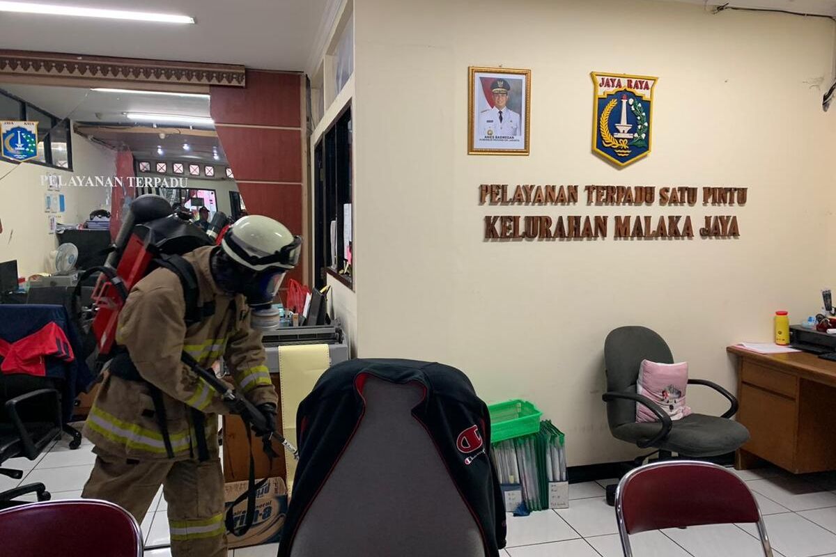 Petugas Damkar Jakarta Timur saat menyemprotkan cairan disinfektan di Kantor Kelurahan Malaka Jaya, Jakarta Timur, Jumat (20/3/2020).