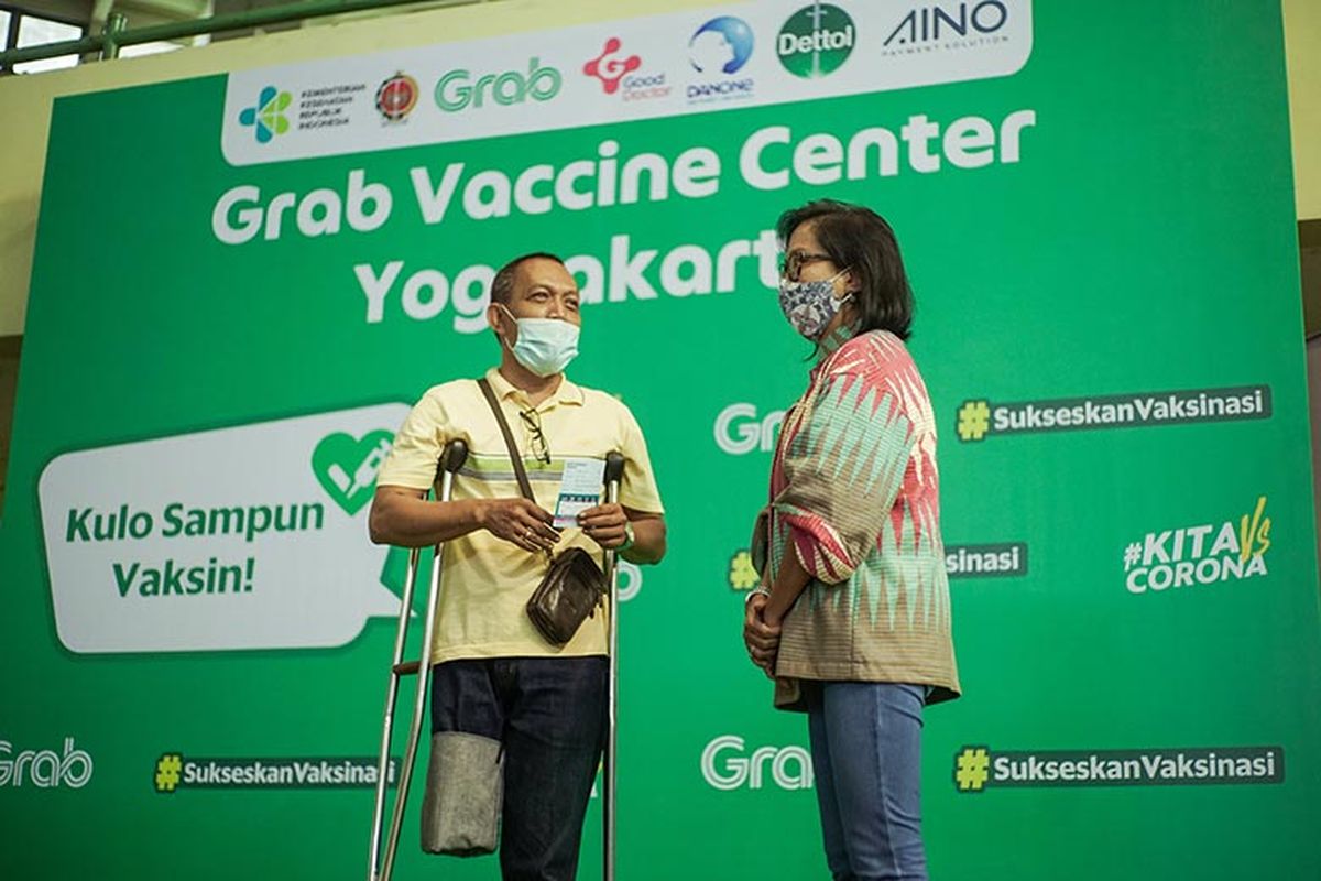 Neneng Goenadi, Country Managing Director Grab Indonesia (kanan) saat menyapa salah satu
penerima vaksin dari kalangan disabilitas di Grab Vaccine Center DI Yogyakarta.