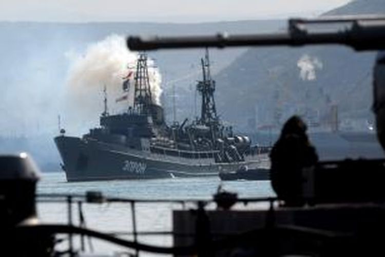 Sebuah kapal perang Rusia berlayar di hadapan kapal perang Ukraina, Ternopil, di teluk Sevastopol, Crimea tak jauh dari pangkalan Armada Laut Hitam Rusia.