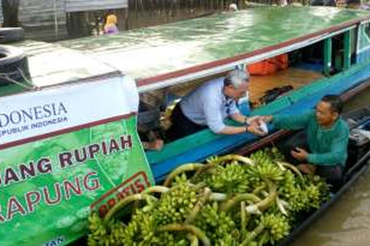 Bank Indonesia Perwakilan Provinsi Kalimantan Selatan melakukan kegiatan kas keliling menggunakan perahu di pasar terapung Lok Baintan, Kab. Banjar, Kalimantan Selatan, Kamis (12/5/2016). Kegiatan ini bertujuan  mendistribusikan rupiah layak edar sekaligus mendukung kelancaran transaksi pembayaran masyarakat.