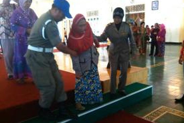 Prengilah dibantu dua anggota satpol PP menuruni tangga usai bersalaman dengan Sri Sultan HBX
