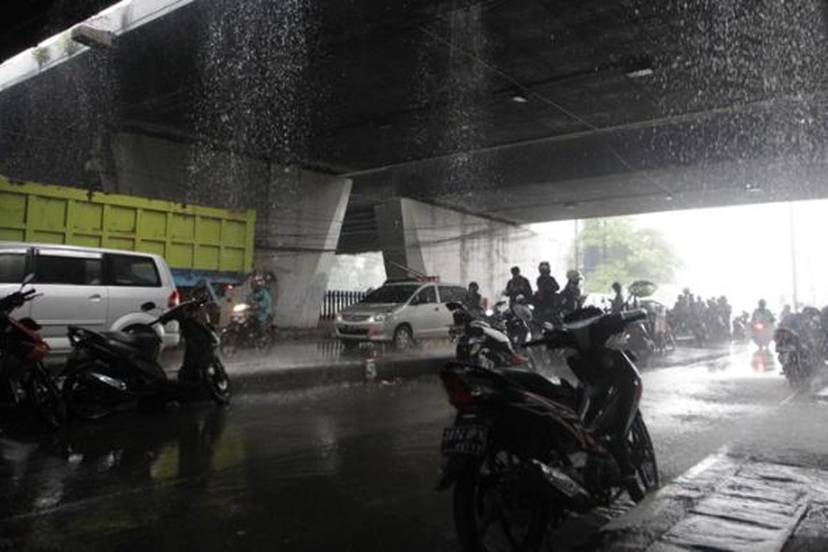 Pengendara motor berteduh di bawah jembatan di kawasan Slipi, Jakarta, Jumat (14/11/2014). Badan Meteorologi, Klimatologi, dan Geofisika (BMKG) memperkirakan wilayah DKI Jakarta diguyur hujan dengan intensitas ringan hingga sedang pada siang hingga malam hari. KOMPAS IMAGES/RODERICK ADRIAN MOZES