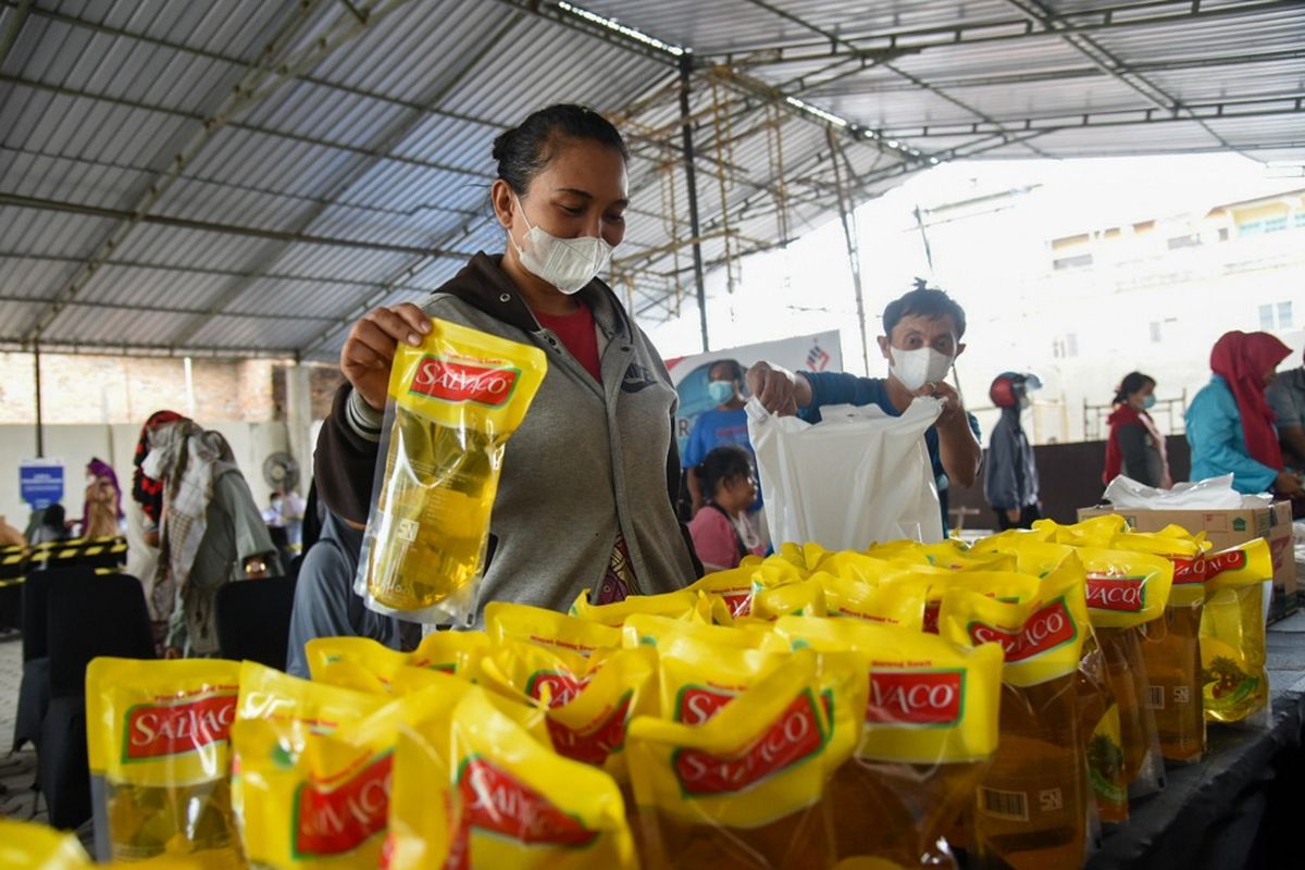 Warga membeli  minyak goreng dengan harga murah di Pasar Murah Kementerian BUMN di Medan, Sumatera Utara, Kamis (7/4/2022). Kementerian BUMN bersama perusahaan BUMN mengadakan pasar murah guna membantu masyarakat memenuhi berbagai kebutuhan pokok saat bulan suci Ramadhan.  ANTARA FOTO/Fransisco Carolio/Lmo/hp.
