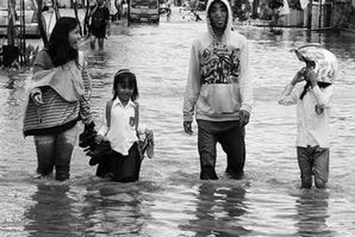  Dillah (kedua dari kiri) basah kuyup akibat menerobos banjir di Jalan Jenderal Ahmad Yani, Samarinda, Kalimantan Timur, Senin (10/11). Sekolah-sekolah di sepanjang jalan tersebut tidak libur meski banjir. 