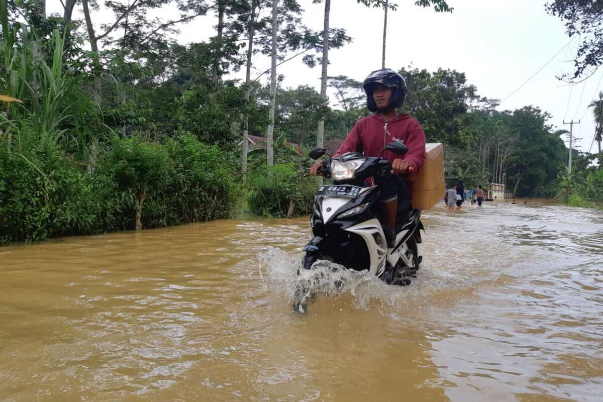 Kendaraan bermotor mencoba melintasi genangan air banjir akibat meluapnya Sungai Citanduy di Desa Tanjungsari, Kecamatan Sukaresik, Kabupaten Tasikmalaya, Minggu (23/2/2020).
