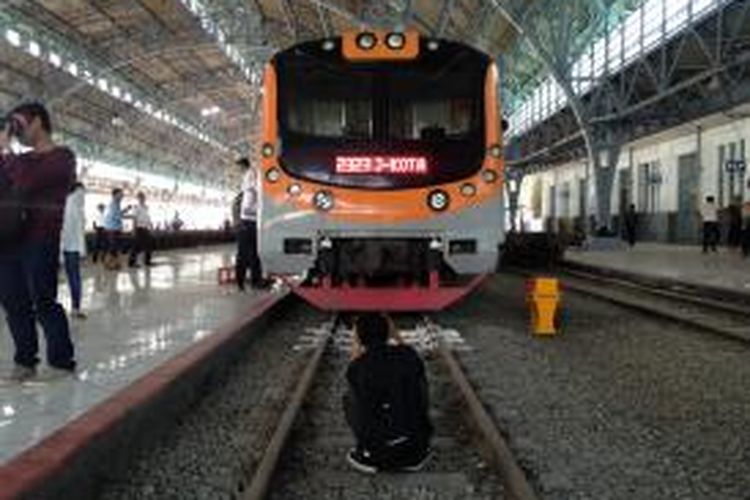 Seorang penumpang tampak jongkok di depan KRL commuter line di Stasiun Tanjung Priok, Jakarta Utara, Senin (21/12/2015). KRL lintas Jakarta Kota-Tanjung Priok resmi dioperasikan hari ini dengan enam perjalanan per harinya. 


