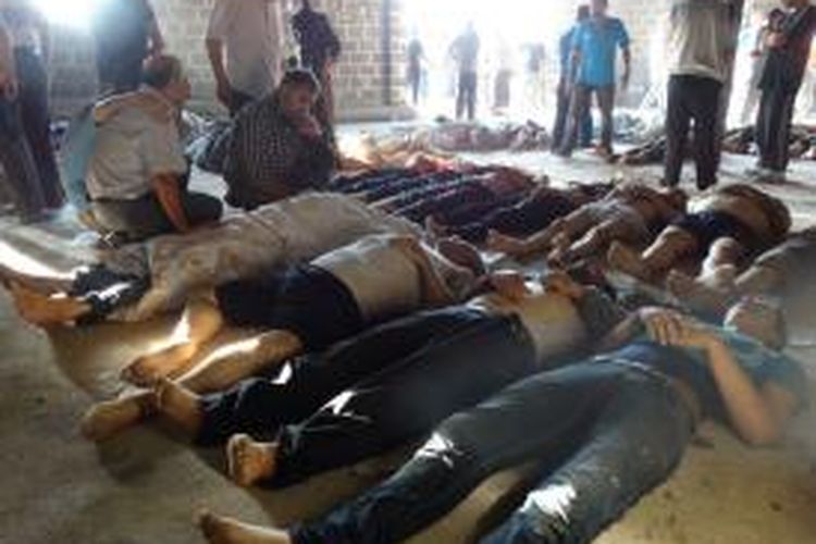 Foto yang dirilis kantor berita oposisi Suriah, Shaam, menampilkan para aktivis oposisi tengah memeriksa korban tewas yang diklaim akibat serangan senjata kimi di Ghouta, dekat Damaskus, Suriah.