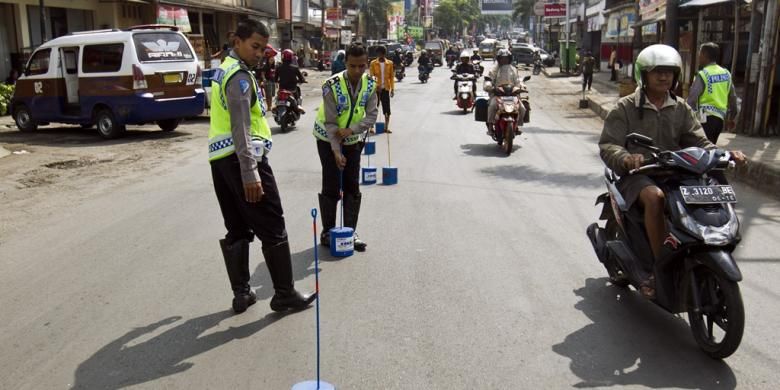 Petugas dari Kepolisian Resor Sumedang memasang marka jalan di seputar Jalan Mayor Abdurahman, Sumedang, Jawa Barat, Senin (29/7/2013). Pemasangan ini untuk memberikan tanda batas jalan karena daerah ini merupakan kawasan padat saat arus mudik berlangsung. 