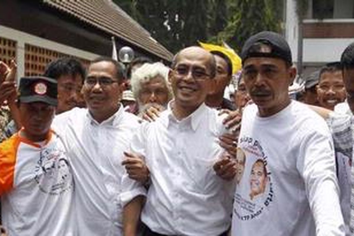 Pasangan Calon Gubernur dan Wakil Gubernur DKI Jakarta, Faisal Basri (tiga kanan) dan Biem Benyamin (dua kiri) dikawal oleh massa pendukung seusai menyerahkan 430.000 berkas dukungan ke KPU Provinsi DKI Jakarta di Perpustakaan Nasional, Jalan Medan Merdeka Selatan, Jakarta Pusat, Sabtu (11/2/2012).  
