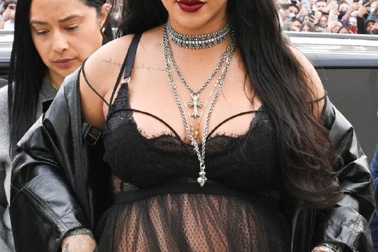 Rihanna tiba di fashion show Dior dengan memakai lingerie hitam sembari memamerkan baby bump-nya.
