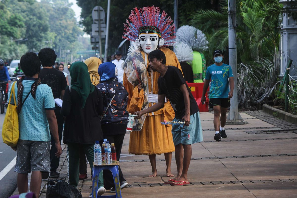 Para pengamen ondel-ondel di kawasan Monumen Nasional, Gambir, Jakarta Pusat, Minggu (9/2/2020). Pemprov DKI Jakarta akan merevisi Peraturan Daerah Nomor 4 Tahun 2015 tentang Pelestarian Kebudayaan Betawi yang di mana ondel-ondel merupakan salah satu kebudayaan khas Betawi.