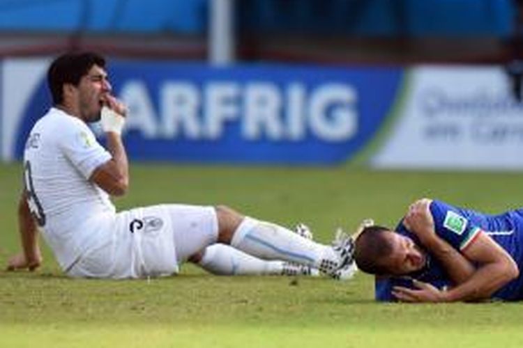 Salah satu ekspresi bek Italia, Giorgio Chiellini (kanan), setelah digigit penyerang Uruguay, Luis Suarez (kiri), pada laga terakhir Grup D Piala Dunia, di Estadio Das Dunas, Natal, Selasa (24/6/2014). 