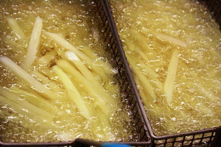 Ilustrasi kentang sedang di-deep fried. 