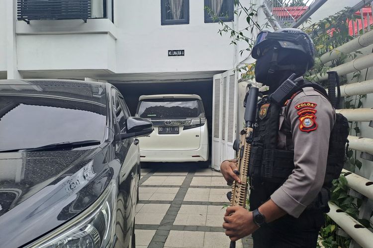 Personel polisi bersenjata lengkap yang berjaga di dalam. pekarangan rumah saat tim penyidik KPK melakukan penggeledahan rumah saudara SYL di Jalan Letjen Hertasning, Kecamatan Rappocini, Kota Makassar, Sulsel, Kamis (16/5/2024).