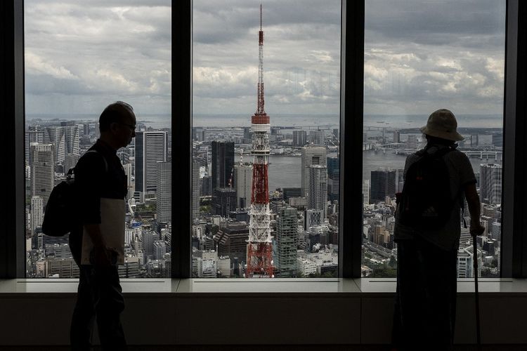 Orang-orang melihat panorama Menara Tokyo dari lantai 52 setelah konferensi pers Azabudai Hills, proyek terbaru dari pengembang properti asal Jepang Mori Building Co., di Tokyo, Selasa (8/8/2023).