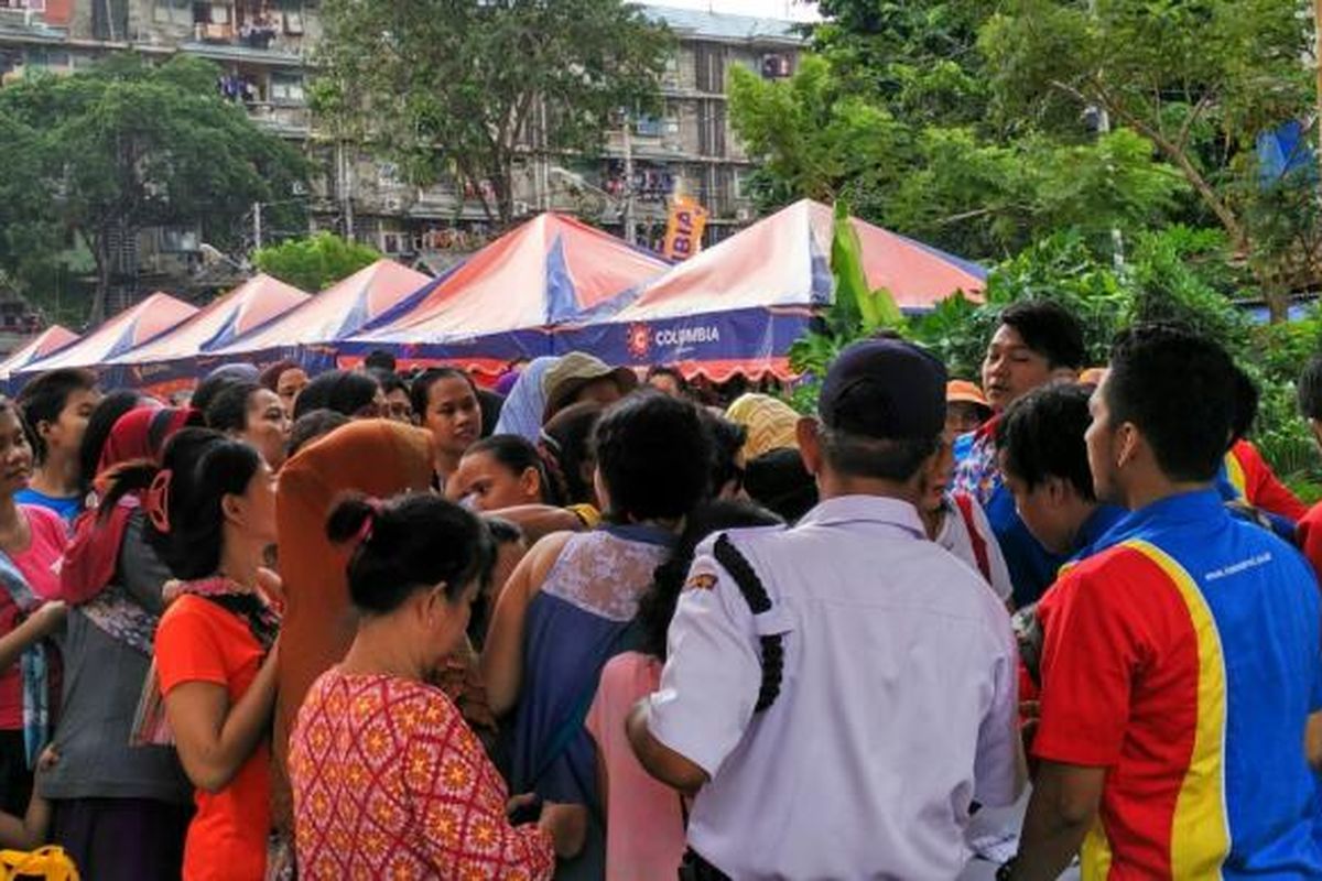 Warga ramai-ramai mengantre di pasar murah Rusun Tambora untuk membeli paket sembako, Senin (13/6/2016).