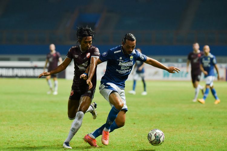 Penyerang Persib, Ezra Walian (biru), mencoba melepaskan diri dari kawalan bek PSM Makassar Erwin Gutawa (merah) saat kedua tim bertemu di pekan keenam Liga 1 2021-2022 di Stadion Wibawa Mukti, Cikarang, Sabtu (2/10/2021). 