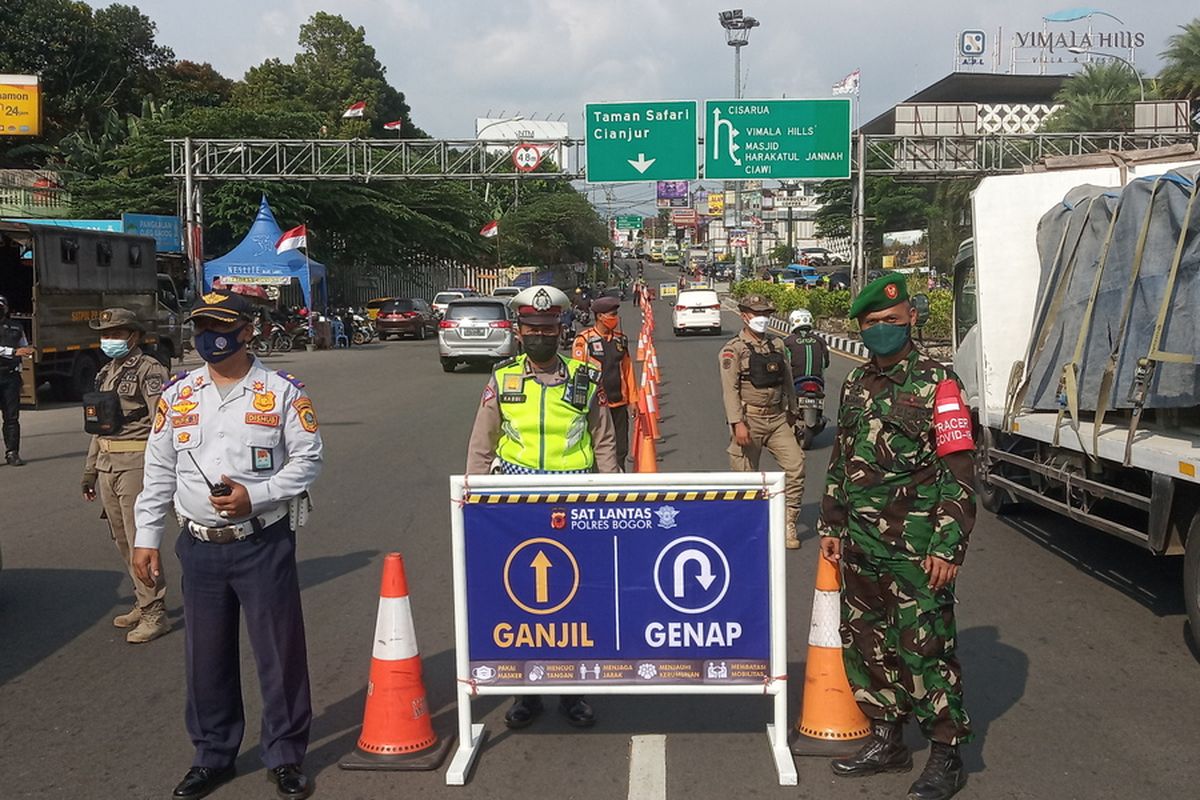 Petugas gabungan sedang menjaga pemeriksaan ganjil genap di Simpang Gadog, Kecamatan Ciawi, Kabupaten Bogor, Jawa Barat.