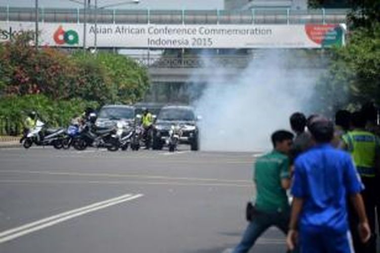 Polisi bersembunyi di balik kendaraan saat terjadi baku tembak dengan terduga pelaku yang berada di dekat sebuah kafe setelah ledakan menghantam kawasan Jalan MH Thamrin, Jakarta Pusat, 14 Januari 2016. Serangkaian ledakan menewaskan sejumlah orang.